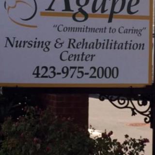 A sign for Agape Nursing & Rehabilitation Center with a contact number.