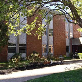 A modern educational building surrounded by greenery.