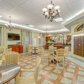 A beautifully decorated lounge area with modern seating, chandeliers, and a television.