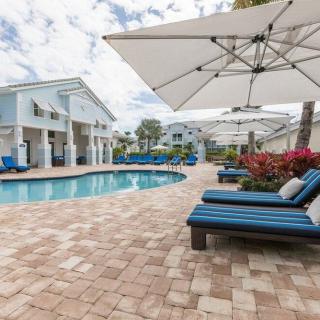 A relaxing poolside area with sun loungers and umbrellas at a resort.