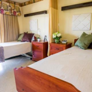 A cozy bedroom with two neatly made beds and wooden nightstands.