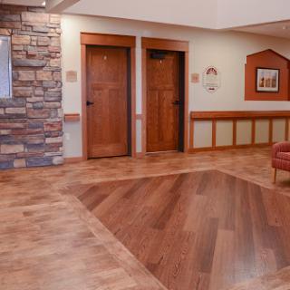 A welcoming lobby featuring wooden doors, a stone accent wall, and stylish flooring.