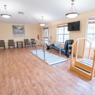 A spacious physical therapy room equipped for rehabilitation exercises.