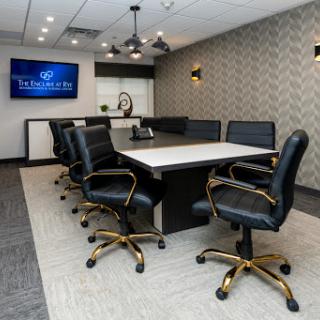 A modern conference room designed for meetings, featuring a large table and comfortable black chairs.