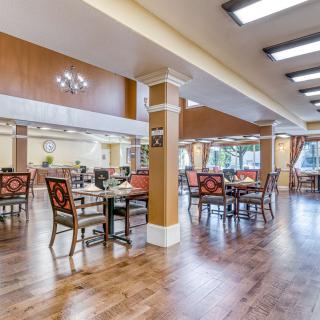 A spacious and elegantly designed dining area with wooden flooring and stylish furniture.
