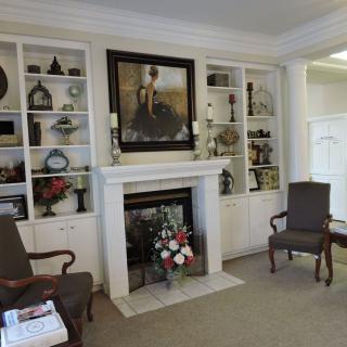 A cozy living room with a fireplace and decorative shelves.