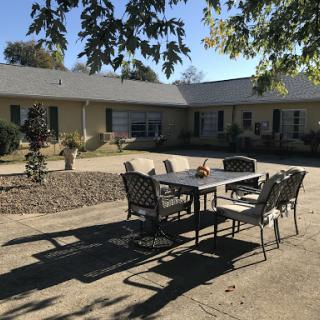 A sunny outdoor patio setup with a table and chairs, perfect for gatherings.