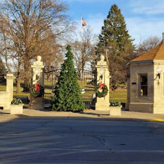 A beautifully decorated entrance to a park, featuring holiday wreaths and a Christmas tree.