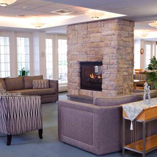 A cozy living room with a central stone fireplace and comfortable seating.
