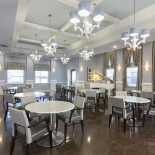 A modern dining room with elegant lighting and neatly arranged tables and chairs.