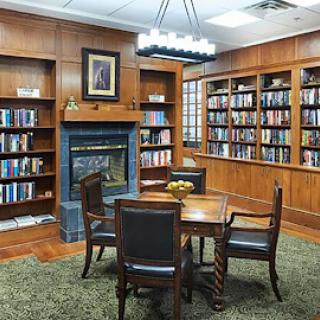 A cozy library with wooden interiors, shelves filled with books, and a comfortable reading area.