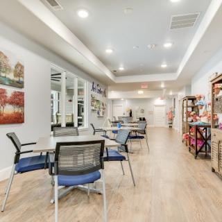 A modern office waiting area with chairs, tables, and bright lighting.
