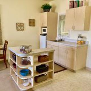 A modern kitchen with a central island featuring open shelves.