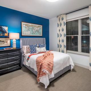 A modern bedroom with a blue accent wall and stylish decor.