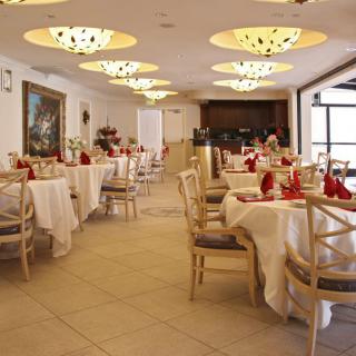A well-decorated restaurant dining area with elegantly set tables and stylish chandeliers.