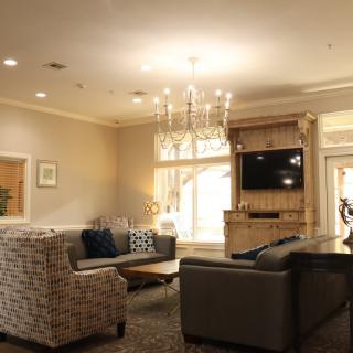 A cozy living room with elegant furnishings and a chandelier.