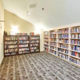 A cozy library room filled with neatly arranged books on shelves.