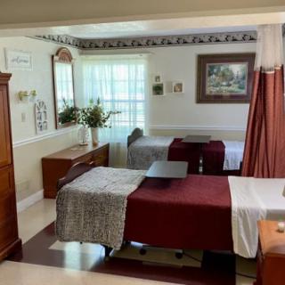 A cozy bedroom with two beds, decorated with warm colors and natural light from a window.