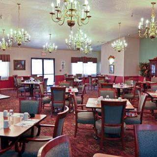 An elegant dining room with multiple tables and chandeliers.