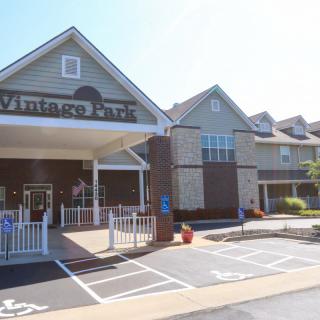 A building with a covered entrance and adjacent parking spaces.