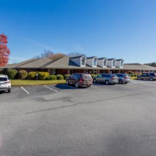 A parking lot in front of a large building on a clear day.