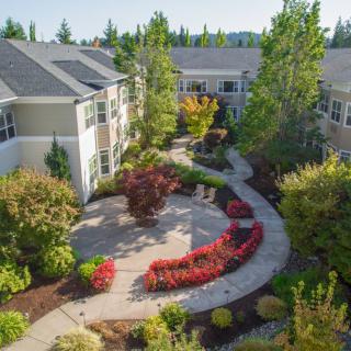 A beautifully landscaped garden with a winding pathway in an apartment complex.