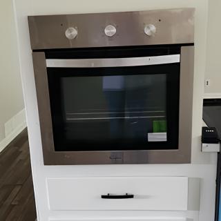 A modern stainless steel built-in oven in a kitchen setting.