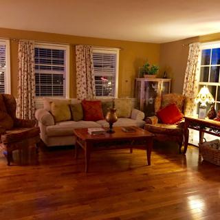 A cozy living room with a sofa, coffee table, and warm lighting.