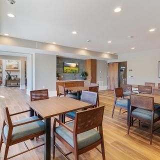 A modern dining area with wooden tables and chairs, featuring a warm and inviting interior design.