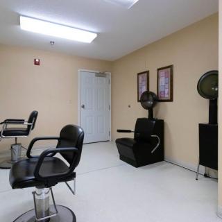 An empty salon with chairs and hair dryers ready for clients.