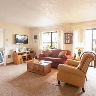 A cozy living room with a sofa, armchair, and television.