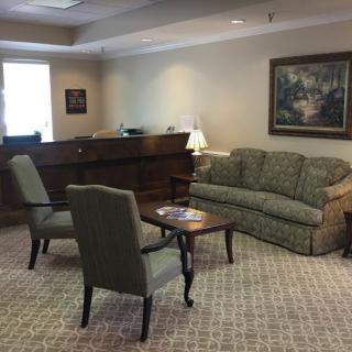 A cozy waiting room with a sofa, armchairs, and a coffee table.