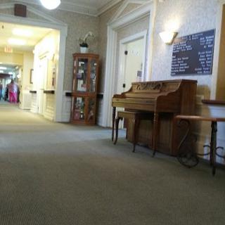 A serene hallway featuring a piano and warm decor, inviting a sense of calm.