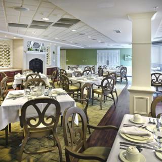 Elegant dining area with neatly set tables and ornate chairs.