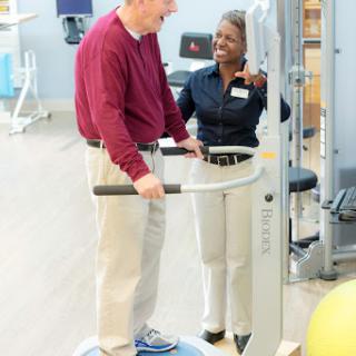 A personal trainer guiding a client during a fitness session.