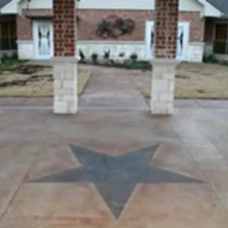 A concrete walkway with a star design leading to a building entrance.
