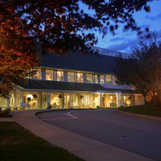 A well-lit building surrounded by trees during the evening.