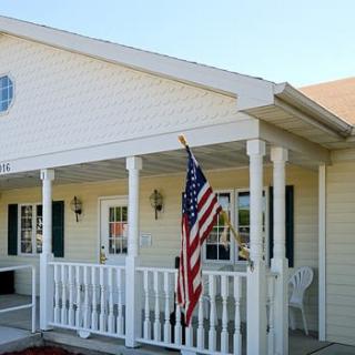 A residential house with a porch and an American flag.