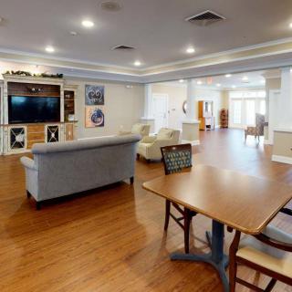 A spacious living area with a television, comfortable seating, and hardwood flooring.