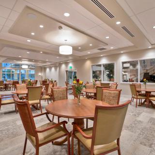 A spacious and well-lit dining area with neatly arranged tables and chairs.