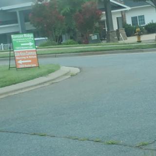 A view of a street corner with signage and landscaped grass.