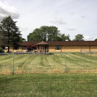 A picturesque view of a building surrounded by well-maintained grass and trees.