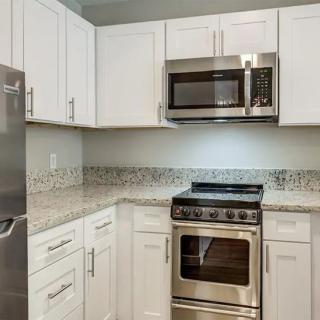 A modern kitchen featuring stainless steel appliances and white cabinetry.