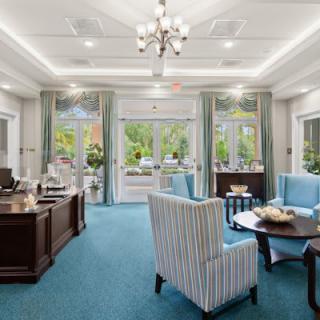 A well-decorated office space with desks, chairs, and large windows.