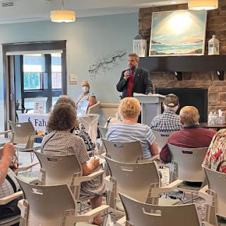 A speaker addresses an audience during a community meeting.