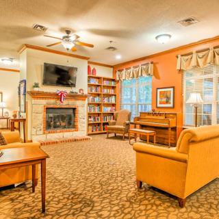 Cozy living room with a fireplace, bookshelves, and comfortable seating.