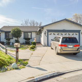 A suburban house with a driveway and parked van in the daytime.