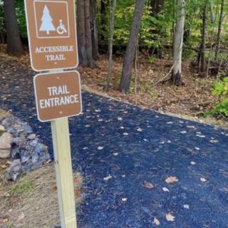 Entrance to an accessible trail in a forested area.