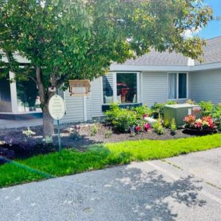 A well-maintained garden with colorful flowers in front of a house.