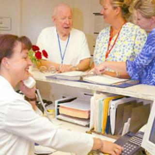 Hospital staff interacting at a reception desk.